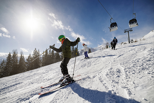 Mother and two teenage kids are skiing together in high mountains on a sunny winter day. 
Shot with Canon R5