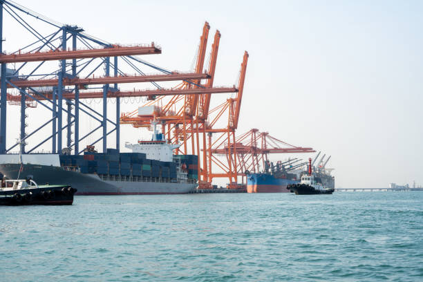 Big crane loading cargo container from truck to container ship in the international terminal logistic sea port concept freight shipping by ship, forwarder mast shipping