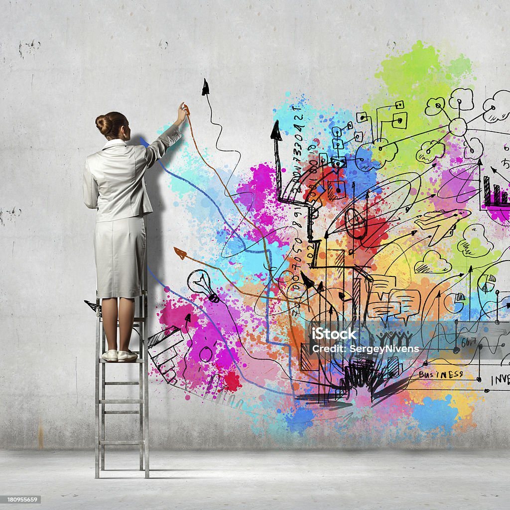 Back view of businesswoman Back view of businesswoman drawing colorful business ideas on wall Adult Stock Photo