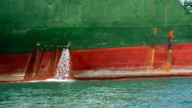 bilge water pumped out of the side of a Cargo Container ship. bilge water pumped out of the side of a Cargo Container ship. bilge of ship stock pictures, royalty-free photos & images