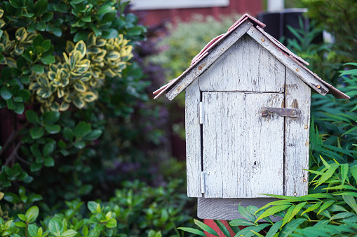 The old wooden letter box in tree leaf environment, gardening object and decoration photo. Close-up.