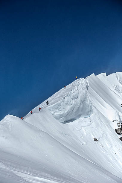 Mountaineers climbing a snowy ridge stock photo