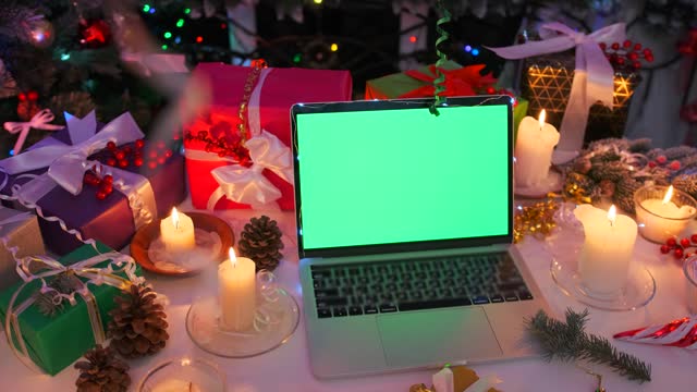 Close up laptop with empty green screen among beautiful Christmas decorations
