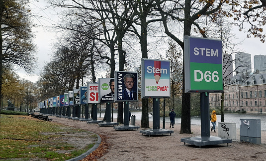 The Hague, Netherlands - November 8, 2023: Dutch Parliament Building Exterior, People Walking Around, Dutch House Of Representatives Early General Elections Poster, Water, Tree Scene During Autumn Season