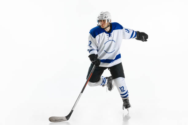 istock Dynamic image of young man, hockey player in motion on rink, training, playing against white studio background 1809599747