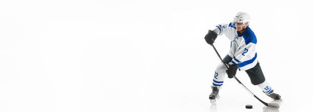 istock Man, hockey player with stick and puck, playing, training on rink against white studio background 1809599752