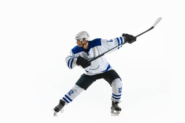 istock Man, ice hockey player in motion during game with stick, training, playing against white studio background 1809599894