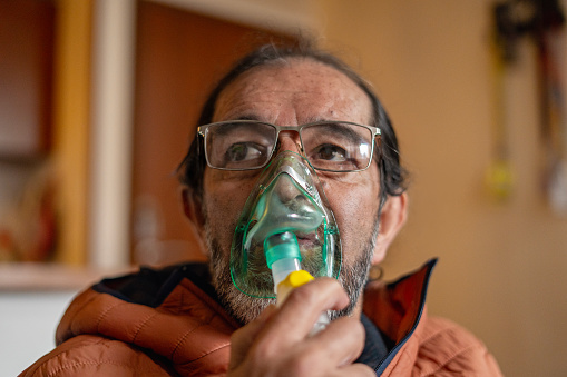 Older Latino man receiving oxygen cylinder treatment for Chronic Obstructive Pulmonary Disease, treatment is the best medicine, concept respiratory diseases.