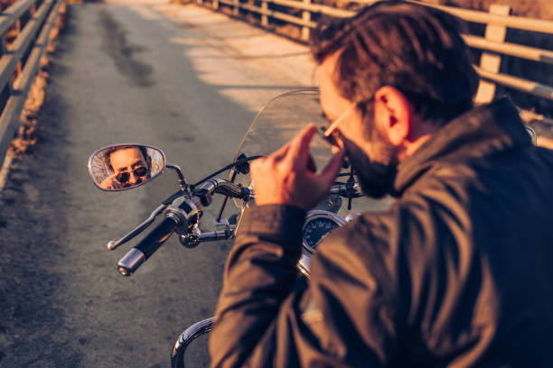 istock Motorcyclist looking in rear view mirror 1809604717