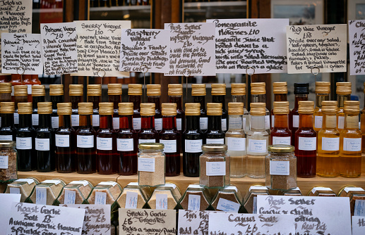 A specialist stall in Borough Market in Southwark, South East London, selling various flavoured vinegars, salts and other seasonings.