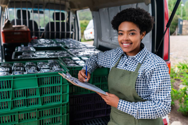 Woman loading a truck with a blueberry order ready for distribution