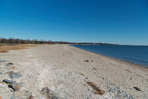 An empty beach at sherwood island state park in westport connecticut on a sunny winter day.