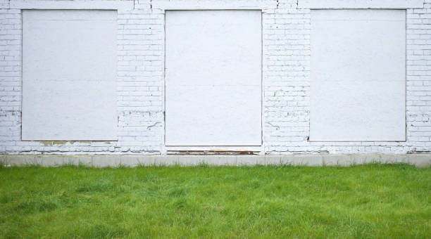 istock White brick wall with openings and green lawn. Space for text. Panorama. 1809630577