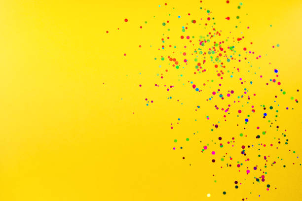 istock colorful confetti on yellow background. flat lay. 1809631719