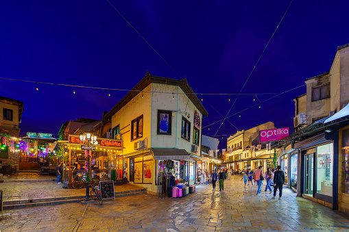 Skopje, North Macedonia - October 06, 2023: Evening street scene in the Old Bazaar quarter, with shops, locals, and visitors. Skopje, North Macedonia
