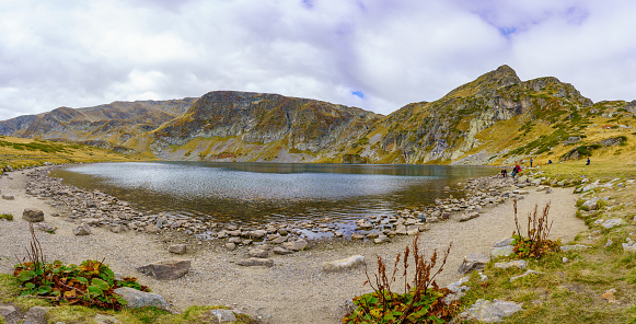 Rila, Bulgaria - October 08, 2023: Panoramic view of the Kidney Lake, with visitors, part of the Seven Lakes, in Rila National Park, southwestern Bulgaria