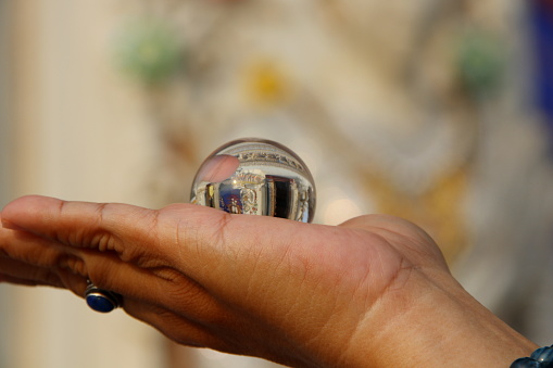 Crystal ball on right lady hand and blur background.