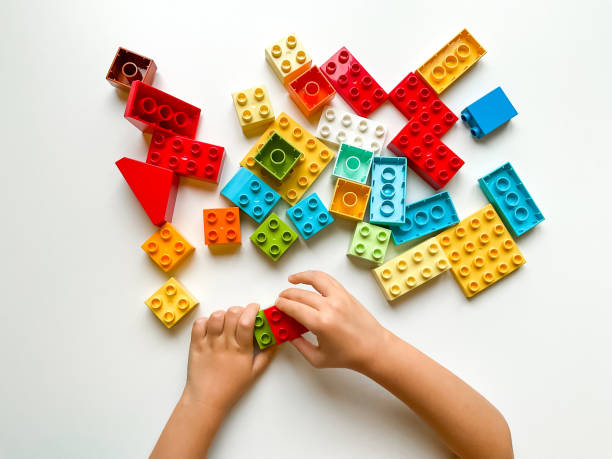 istock Child playing with colorful building blocks on white background. Top view 1809672465