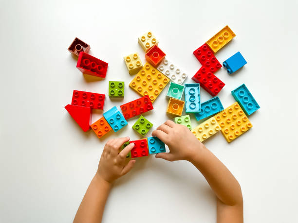 istock Child playing with colorful building blocks on a white background. Top view 1809672478