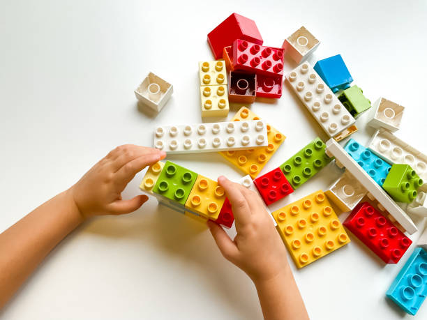 istock Child playing with colorful building blocks on white background. Top view 1809672483