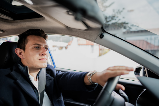 Young businessman driving car