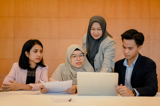 istock Asian colleagues having fun working together using digital laptop in the office 1809683799