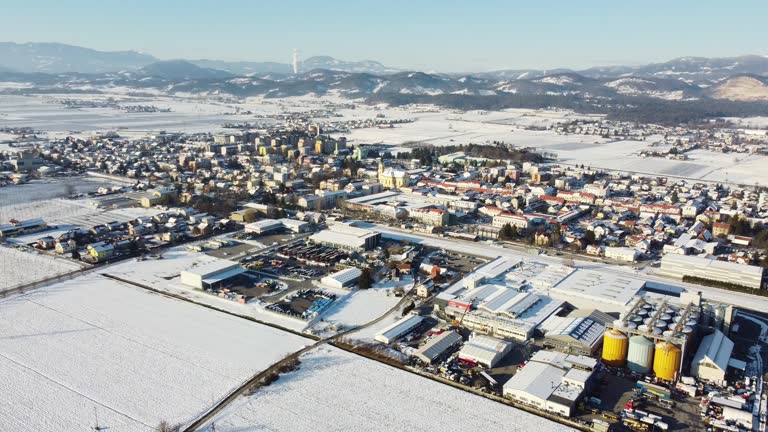 Aerial view of a snow-covered town with buildings and roads amidst a winter landscape.