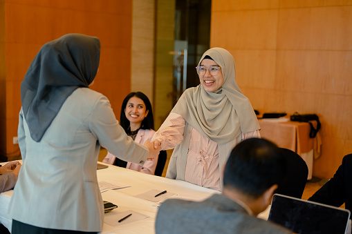 Young asian businesswoman shaking hand with partner