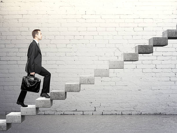 istock Businessman going up a concrete ladder with steady pace 180968714