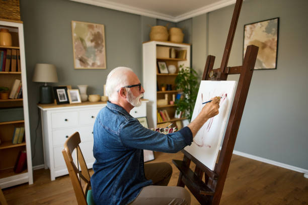 istock Elderly man painting on a canvas at home 1809707142