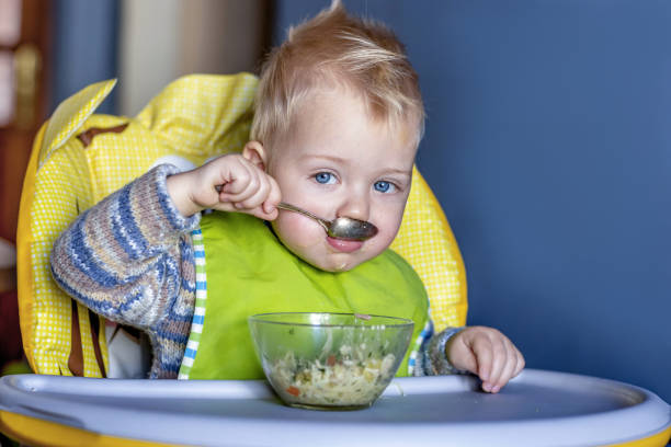 istock The baby eats independently while sitting in a child seat 1809715673