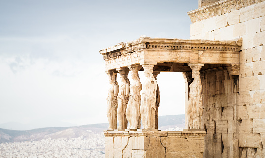 Part of the Erechtheion on the north section of the Acropolis, with the city and hills in the background.