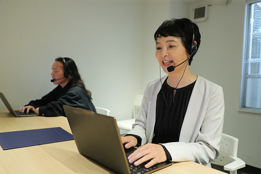Customer service agents with headset.  Customer service representative helping to support their customers over the phone in an office.