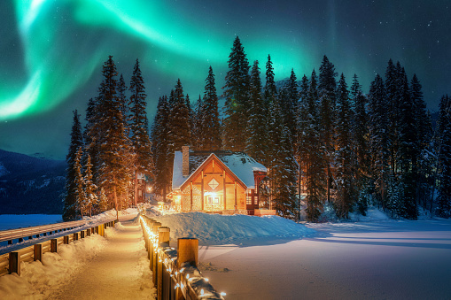 Beautiful Aurora borealis or Northern Lights over Emerald Lake Lodge glowing in the night at Yoho national park, Alberta, Canada