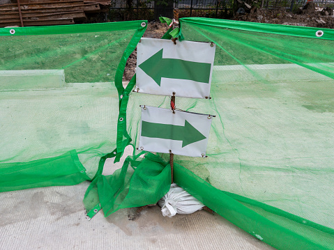 The two way arrow for the direction on the new concrete walkway for temporary use in the construction site of the train station, front view with the copy space.