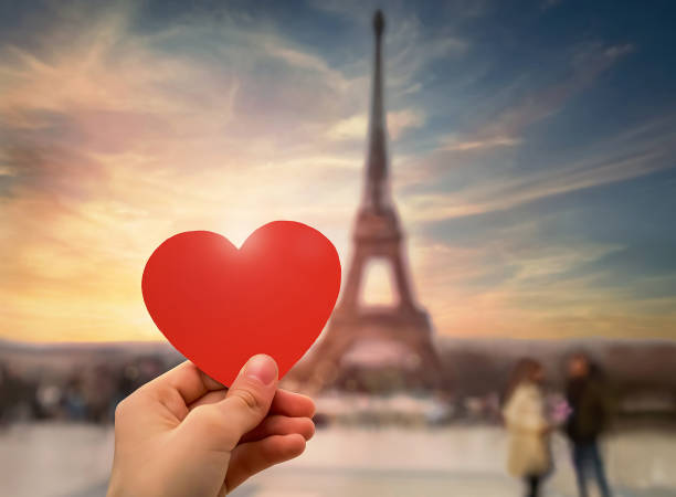 istock Hand holding red heart. Famous Eiffel Tower, evening sky on background. 1809751119