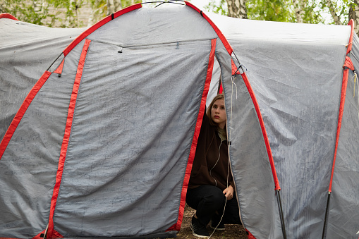 A woman sets up a tent in the forest
