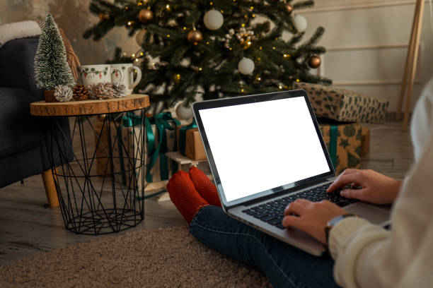 istock Young woman work on laptop computer with blank display screen with mockup copy space. Modern home living room interior design. Christmas, New Year decorated workspace 1809767477