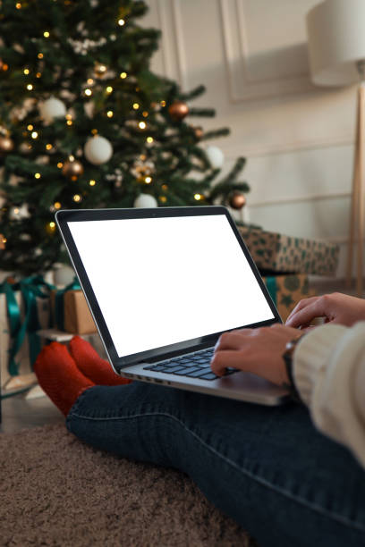istock Young woman work on laptop computer with blank display screen with mockup copy space. Modern home living room interior design. Christmas, New Year decorated workspace 1809767484