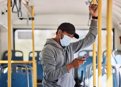 Bus travel, smartphone and man with a mask, safety protection and typing with social media. Person, traveller and guy with face cover, covid regulations or cellphone with public transportation or app