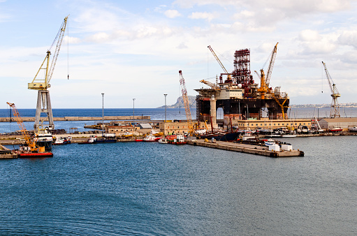 Panoramic landscape view of semi-submersible drilling vessel in dock of Palermo port. Vessel under renovation.