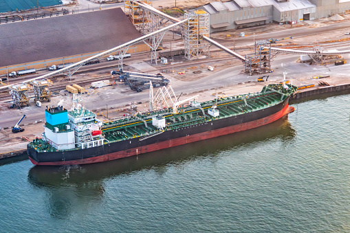 A moored chemical tanker ship along the Houston Ship Channel ready to be loaded with its cargo for international export shot via helicopter from an altitude of about 500 feet.