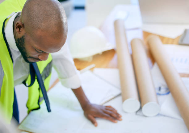 Blueprint, architect and above man in office with paper, design and planning building project. Construction, engineer and top view of male project manager with plan for property, model or renovation