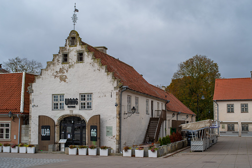Kuressaare, Estonia - October 23 2023: Historical medieval building now operated as WAAG resto bar in Kuressaare city centre on a cloudy autumn day.