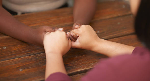 Support, trust and diversity women holding hands for help with emotional problem, mental health crisis or depression. LGBTQ bond, lesbian love and black woman or couple helping with anxiety together