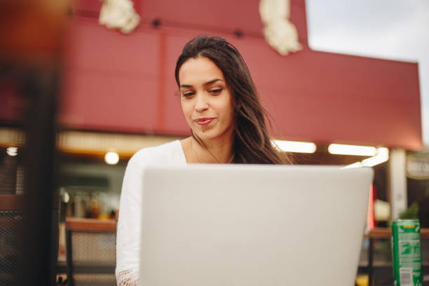 istock Young women using her laptop outdoors stock photo 1809882611