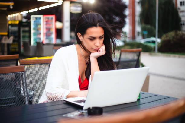 istock Young women using her laptop outdoors stock photo 1809883753