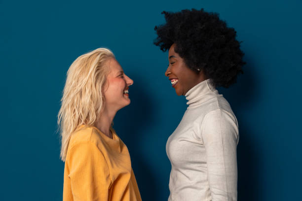 istock Two cheerful young women with different skin tones smiling at each other 1809886537