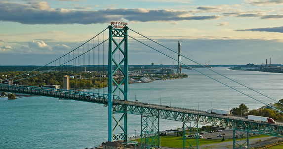 Aerial view of traffic crossing the Ambassador Bridge between Detroit, Michigan and Windsor, Ontario at sunset on a Fall evening.