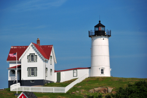 York, Maine, New England, USA: Cape Neddick Lighthouse and the keeper's house with flag pole - Nubble Light - photo by M.Torres